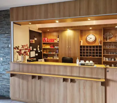 a counter in a restaurant with a clock on the wall at Hotel NED HOCKEY in Nymburk