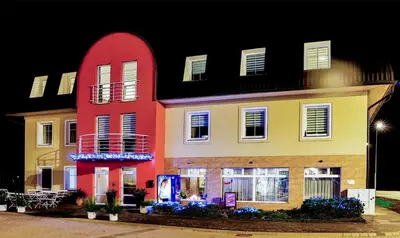 a brightly colored building with a red at Hotel NED HOCKEY in Nymburk