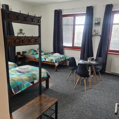 a bedroom with two beds and a table and chairs at Penzion a Restaurace Simanda in Prague