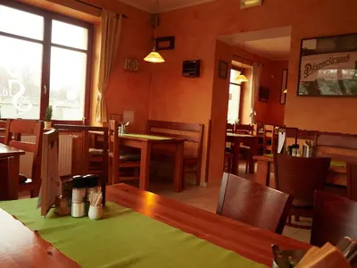 a restaurant with wooden tables and chairs and a large window at Penzion a Restaurace Simanda in Prague