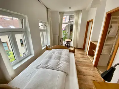 a large bed in a room with two windows at Family Lorenz & Coffee House in Prague