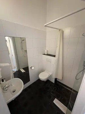a white bathroom with a toilet and a sink at Family Lorenz & Coffee House in Prague