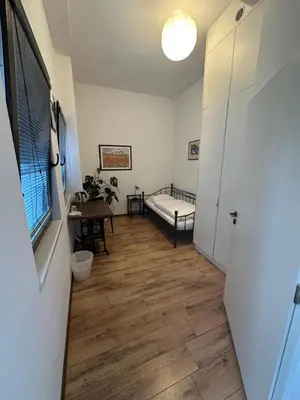 a hallway with a room with a bed and wooden floors at Family Lorenz & Coffee House in Prague