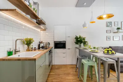 a kitchen with a sink and a table with stools at APT with sunny garden Prague by Michal&Friends in Prague