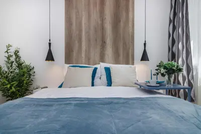 a bed with blue and white pillows and a table at APT with sunny garden Prague by Michal&Friends in Prague