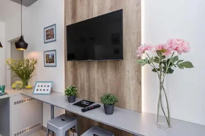 a living room with a table with a tv and flowers at APT with sunny garden Prague by Michal&Friends in Prague