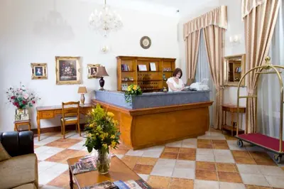 a woman standing behind a counter in a living room at Chateau Zbiroh in Zbiroh