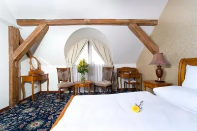 a bedroom with a bed and a table and chairs at Chateau Zbiroh in Zbiroh