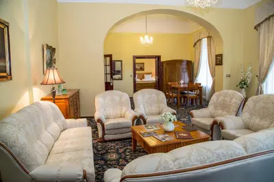 a living room with white couches and a table at Chateau Zbiroh in Zbiroh