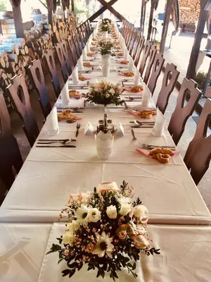 a long table with white linens and flowers on it at Restaurant a penzion Pod Draci skalou in Karlštejn