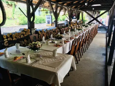 a long row of tables and chairs in a warehouse at Restaurant a penzion Pod Draci skalou in Karlštejn