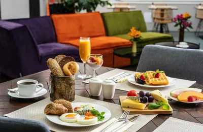 a table topped with plates of breakfast foods and drinks at NYX Hotel Prague by Leonardo Hotels in Prague