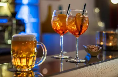 three glasses of beer sitting on a bar at NYX Hotel Prague by Leonardo Hotels in Prague