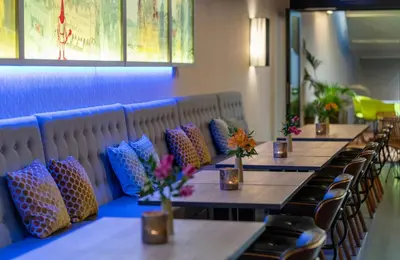 a row of tables in a restaurant with colorful pillows at NYX Hotel Prague by Leonardo Hotels in Prague
