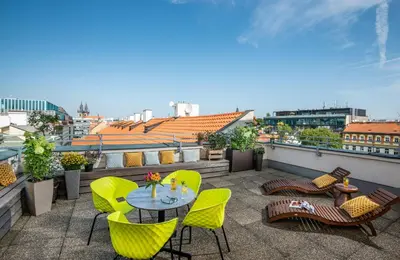 a patio with yellow chairs and a table on a balcony at NYX Hotel Prague by Leonardo Hotels in Prague