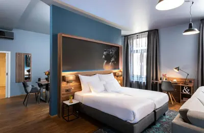 a hotel room with a large bed and a couch at NYX Hotel Prague by Leonardo Hotels in Prague