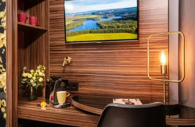 a room with a desk with a tv on a wall at NYX Hotel Prague by Leonardo Hotels in Prague