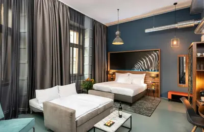 a hotel room with two beds and a couch at NYX Hotel Prague by Leonardo Hotels in Prague