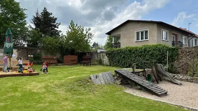 a yard with a playground and a house at Hotel Tynec in Týnec nad Sázavou