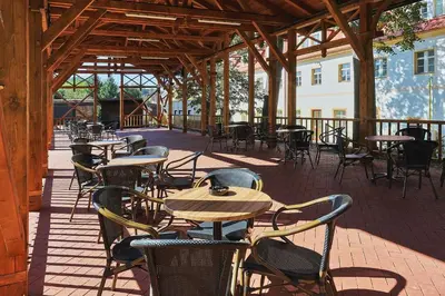 an empty patio with tables and chairs in a building at Hotel Tynec in Týnec nad Sázavou