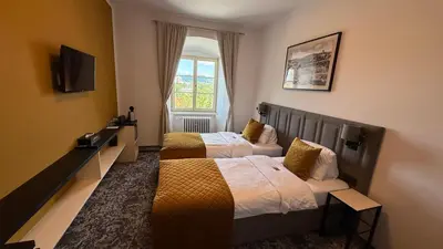 a hotel room with two beds and a window at Hotel Tynec in Týnec nad Sázavou