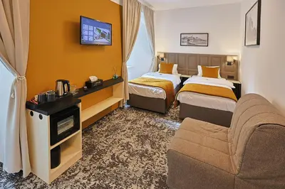 a hotel room with two beds and a couch at Hotel Tynec in Týnec nad Sázavou