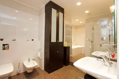 a bathroom with two sinks and a toilet and a shower at Spacious elegance in the heart of Old Town in Prague