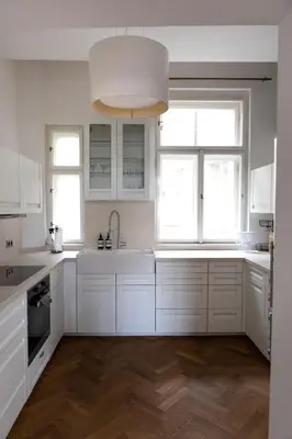 a white kitchen with a sink and two windows at Bright stylish central apartments Prague in Prague