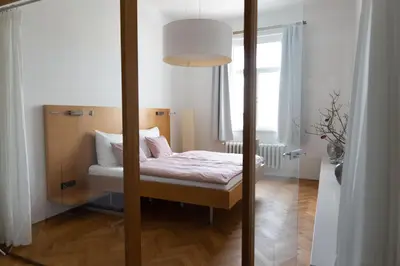 a small bedroom with a bed with a mirror at Bright stylish central apartments Prague in Prague