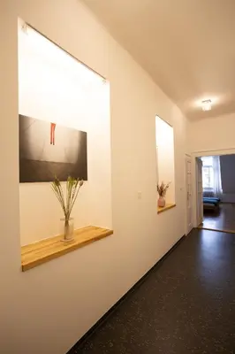 a hallway with a white wall with a window at Bright stylish central apartments Prague in Prague