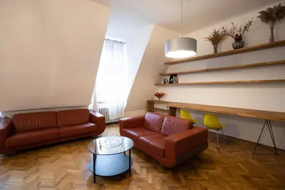 a living room with two couches and a table at Bright stylish central apartments Prague in Prague