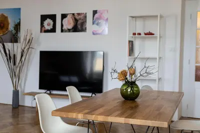 a dining room table with a vase of flowers on it at Bright stylish central apartments Prague in Prague