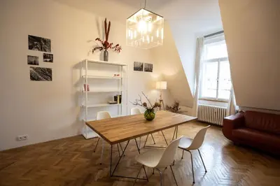 a dining room with a wooden table and white chairs at Bright stylish central apartments Prague in Prague