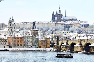 a city in the snow with a bridge and buildings at City centre Apartment Prague by Michal&Friends in Prague