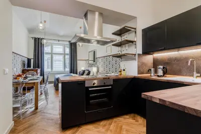 a kitchen with black and white cabinets and a table at Prague Trendy Central Apartment by Michal&Friends in Prague