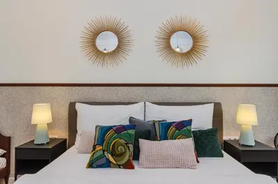 a bedroom with two mirrors above a bed with pillows at Prague Trendy Central Apartment by Michal&Friends in Prague