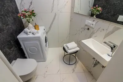 a white bathroom with a toilet and a sink at Prague Trendy Central Apartment by Michal&Friends in Prague