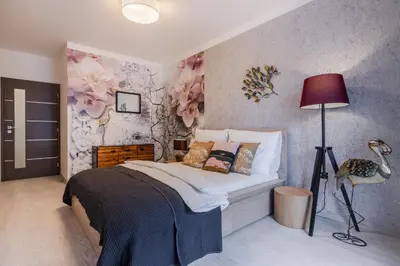 a bedroom with a bed with flowers on the wall at Prague Luxury Apartments Parking by Michal&Friends in Prague