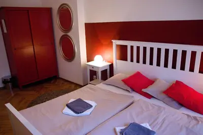 a bedroom with a white bed with red pillows at Budget Apartment in Prague