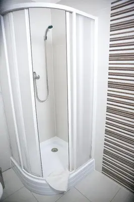 a shower with a glass door in a bathroom at Budget Apartment in Prague