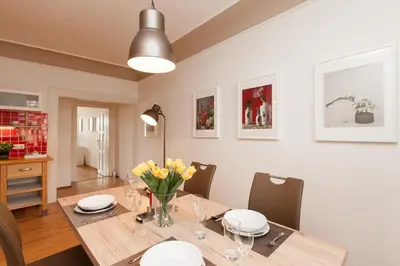 a dining room with a wooden table with yellow flowers at Prague Historic Center Apartments in Prague