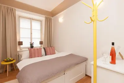 a white bedroom with a bed and a window at Prague Historic Center Apartments in Prague