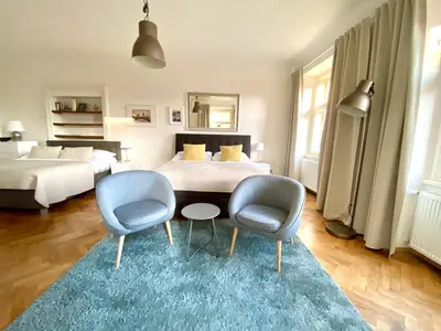a bedroom with two beds and a table and two chairs at Prague Historic Center Apartments in Prague