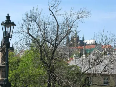 a white bedroom with a large bed and a tv at Prague Historic Center Apartments in Prague