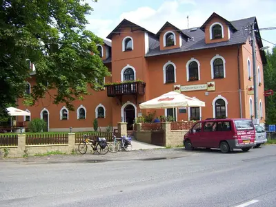 a red car parked in front of a building at Penzion U červených vrat in Chudolazy