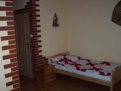 a bedroom with a bed and a brick wall at Penzion U červených vrat in Chudolazy