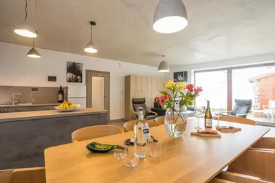 a kitchen and dining room with a wooden table and chairs at Vinný apartmán Rakovník in Rakovník