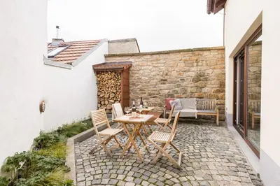 a patio with a table and chairs on a stone floor at Vinný apartmán Rakovník in Rakovník