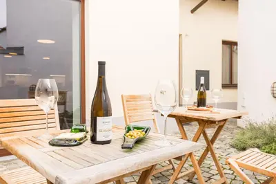 a table with two wine glasses and a bottle of wine at Vinný apartmán Rakovník in Rakovník