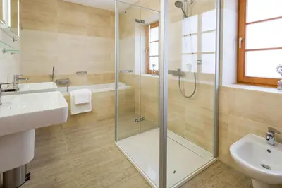 a bathroom with a glass shower and a sink at Vinný apartmán Rakovník in Rakovník